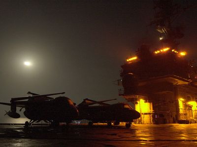 Lights from the USS Kitty Hawk island structure create an eerie cast over two S-3 Viking aircraft on a misty Halloween night.  Kitty Hawk operates out of Yokosuka, Japan as America's only permanently forward-deployed aircraft carrier.  (U.S. Navy photo by Photographer's Mate Airman Michael D. Winter)  (Released)..