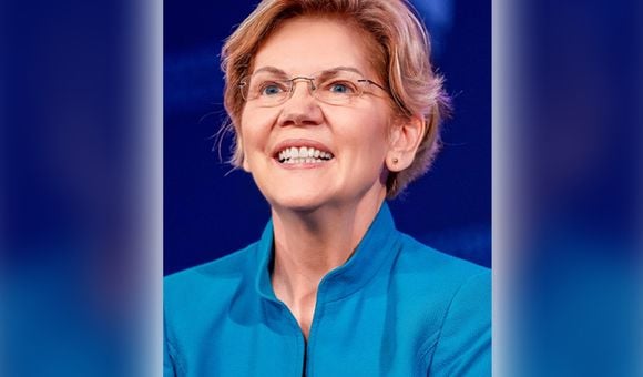 Image of a woman, Elizabeth Warren, smiling in a blue shirt