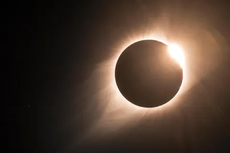 As the 2017 North American total solar eclipse comes to an end, the famous "diamond ring" becomes visible. The sun's corona is also visible, with the star Regulus to the left.
