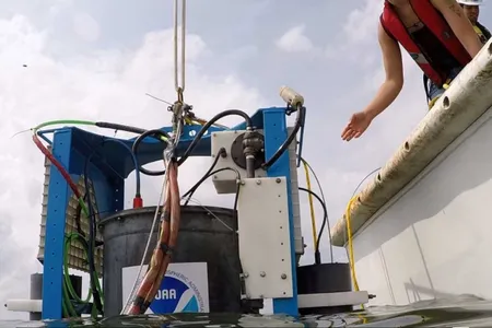An environmental sample processor is lowered into Lake Erie.