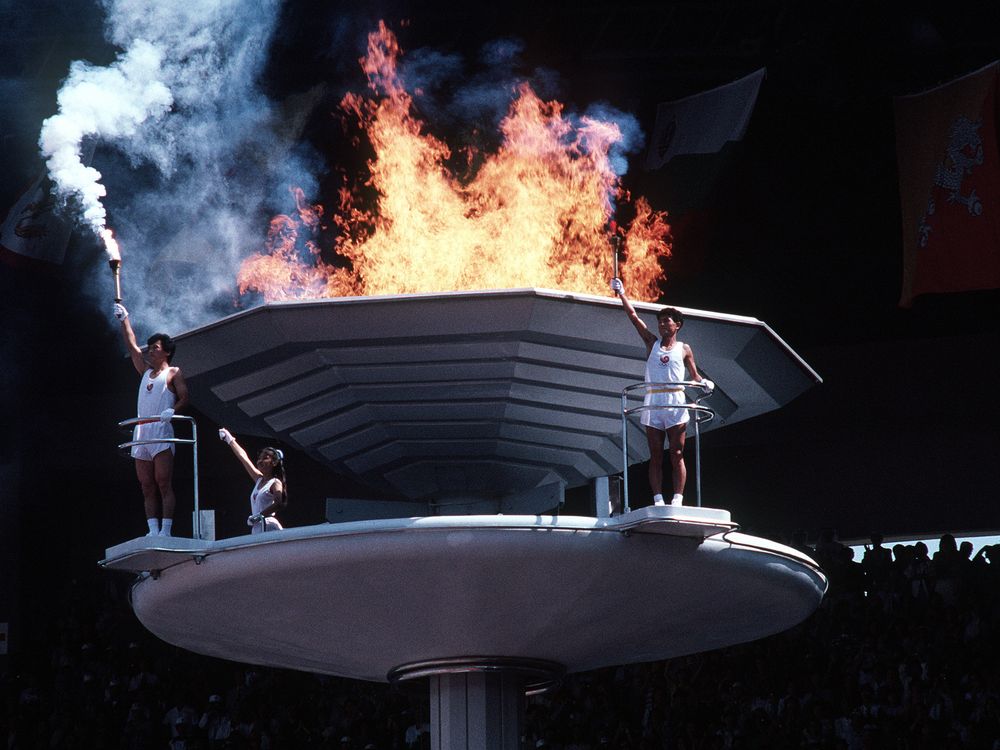 South Koreans stand by the cauldron of the 1988 Summer Olympics