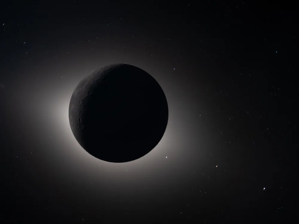 the moon appears as a dark circle with a faint white glow around it in a solar eclipse from space