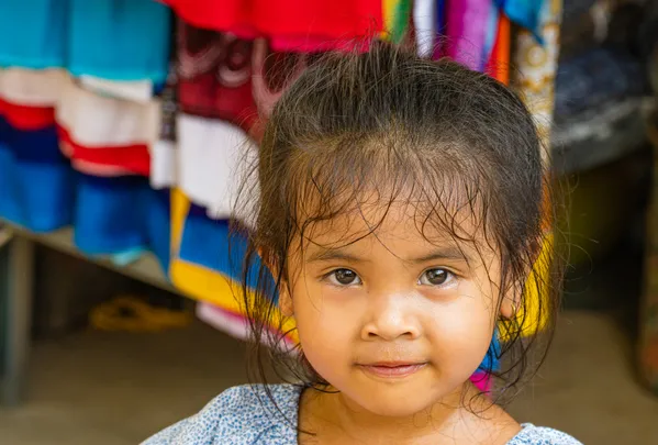 Cambodian child selling tee shirts thumbnail