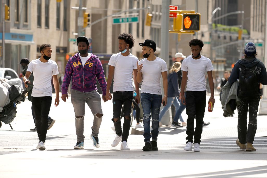 A group of men wearing protective masks walk in Midtown on April 10, 2021 in New York City.
