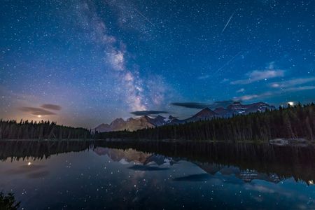 According to Getty: Photographed in July 2018, this view looking south at Herbert Lake, Banff National Park, Alberta, shows the Milky Way over Mount Temple and the peaks of the Continental Divide. To the left in the clouds, Mars is hiding. Then Jupiter flanks the Milky Way on the right, while Saturn sits within the Milky Way.