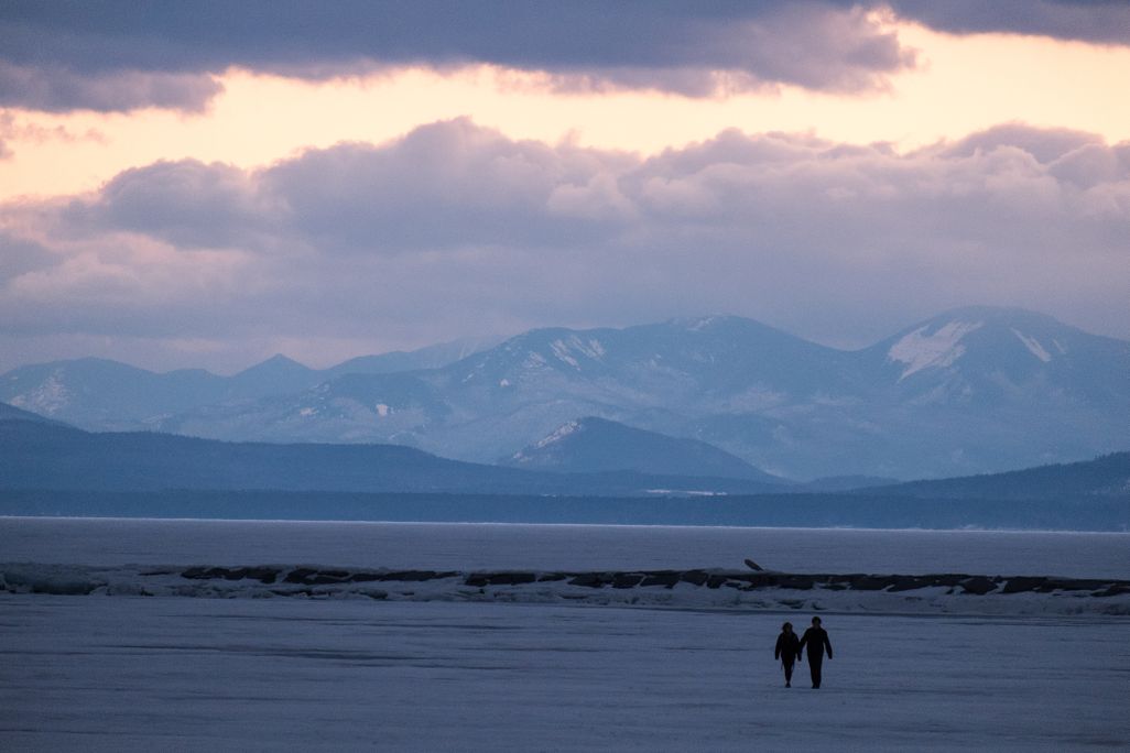 Two people walking on lake champlain