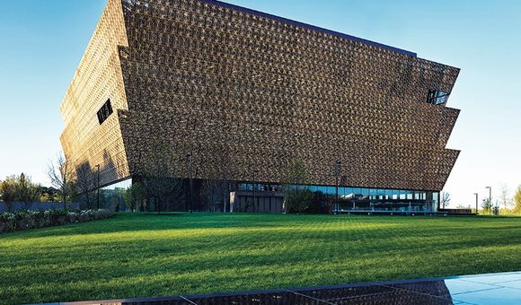 Wrapped in an ornamental bronze latticework, the angular lines of the Museum rise in stark contrast to the rich green landscape.