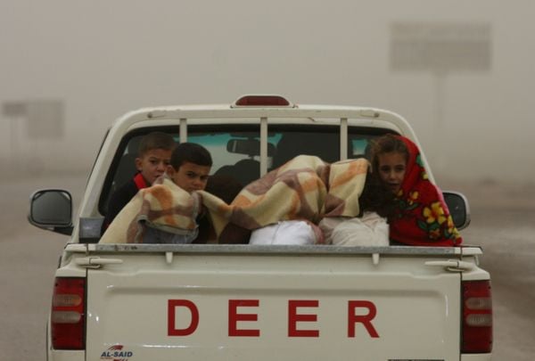 children in back of pickup driving on highway in Iraq thumbnail
