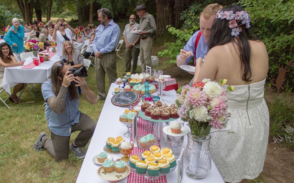 Young couple having their photo taken during a backyard wedding