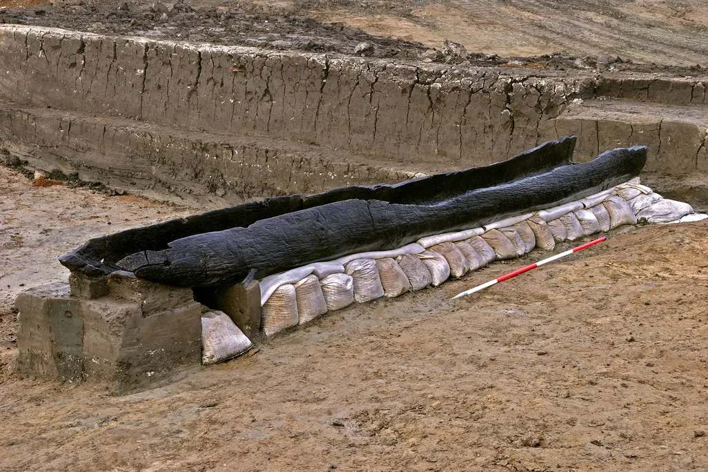 A boat made out of a tree trunk on the ground