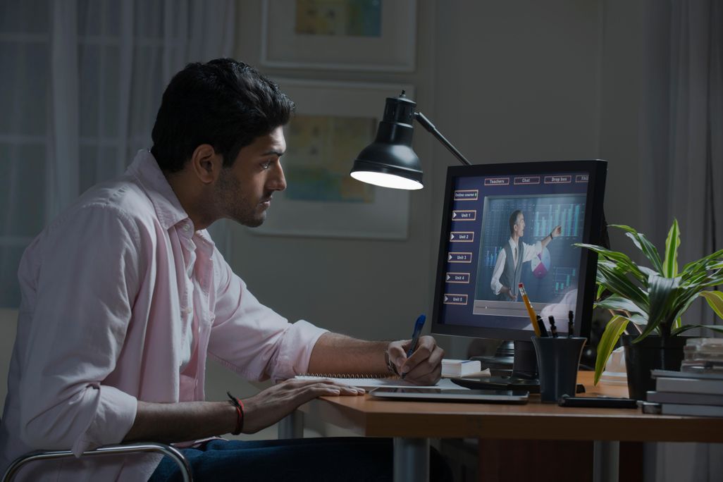 Stock photo image of a man watching a generic lecture on a desktop computer screen