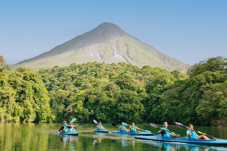 A group kayaking on the beautiful Lake Arenal laying below the Arena Volcano