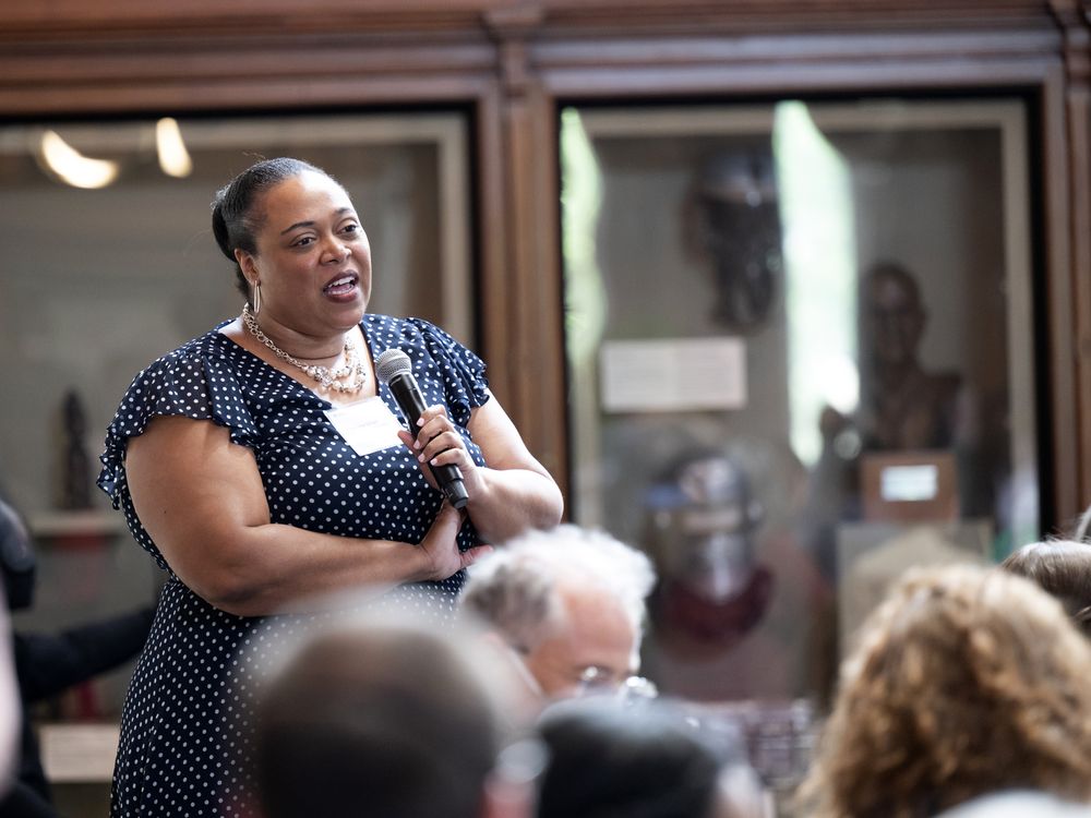 Woman with crossed arms holds a microphone
