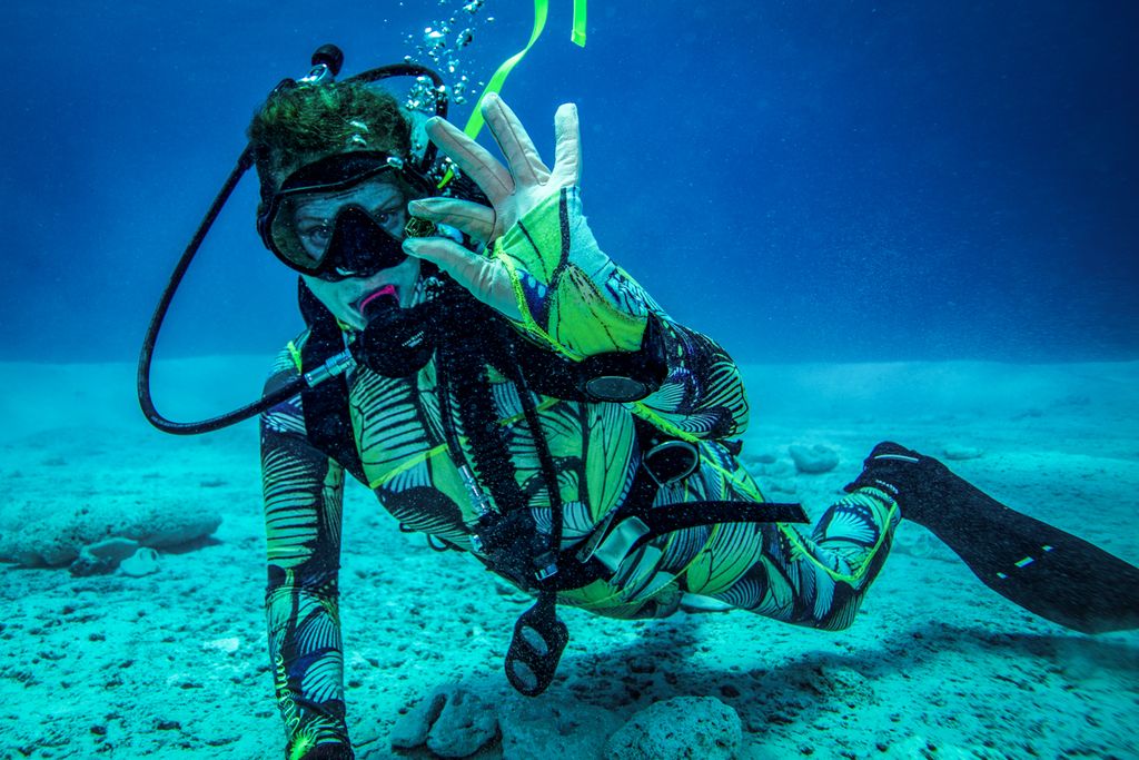 Underwater diver holding up something small