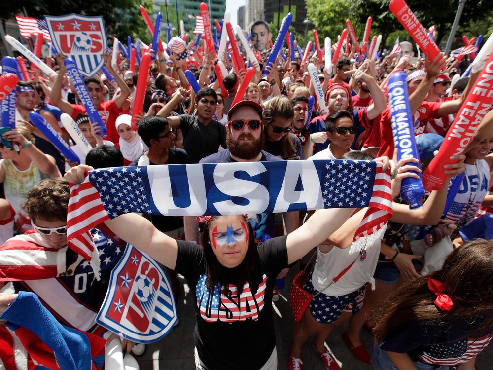Amber Silvani holds up a USA banner as United States fans watch the 2014 World Cup soccer match