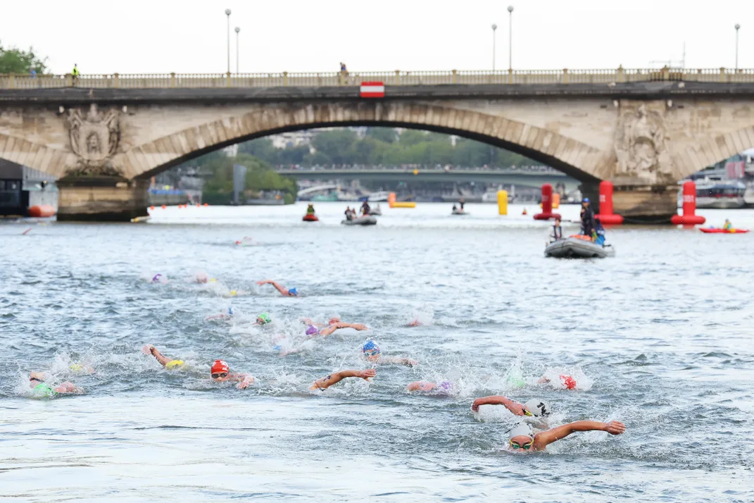 Heads of swimmers as they paddle in the Seine River in Paris