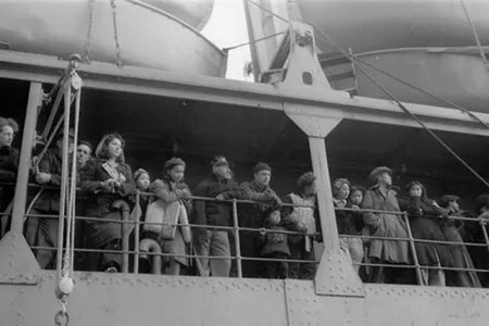 Aleutian people stand on the deck of a ship forcibly evacuating them to southeastern Alaska.
