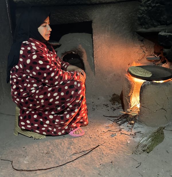 Woman tending fire in her home in Atlas Mountains, Morocco. thumbnail