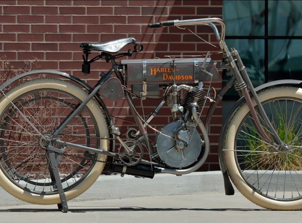 Gray vintage motorcycle in front of brick wall