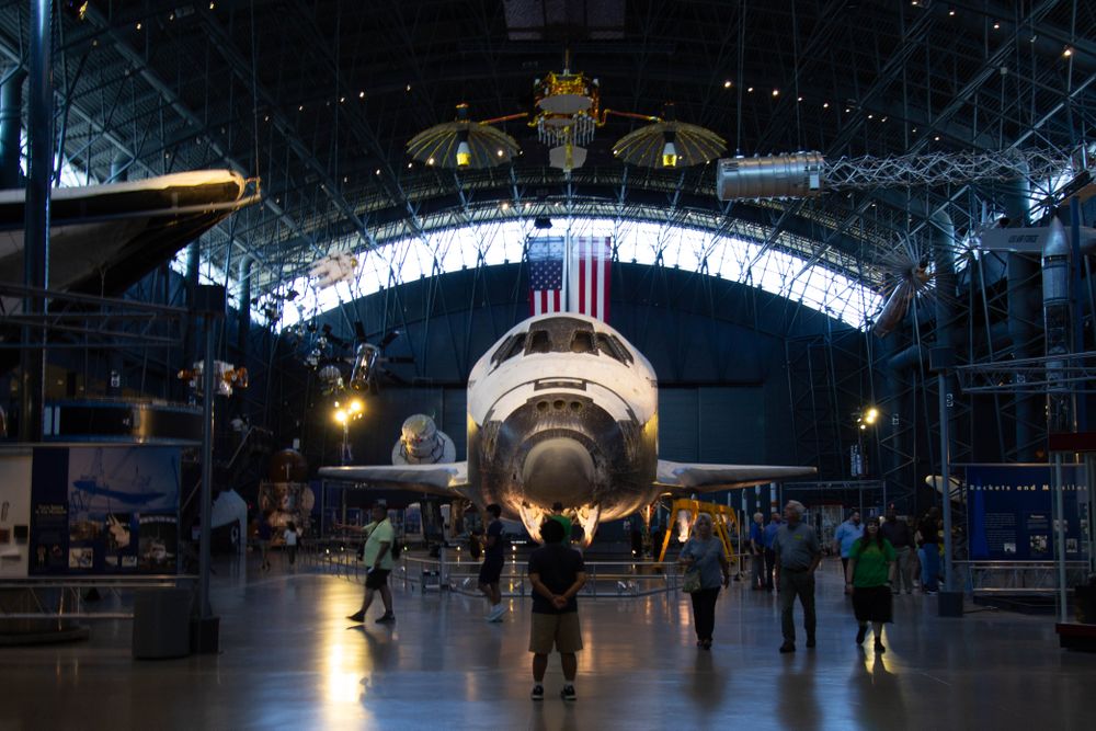 At the National Air and Space Museum Udvar-Hazy Center, a child stands in the presence of Space Shuttle Discovery, its name chosen to carry on a tradition of exploration.