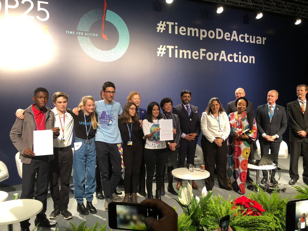 Sara Cognuck (center) shows the Declaration on Children, Youth and Climate Action.