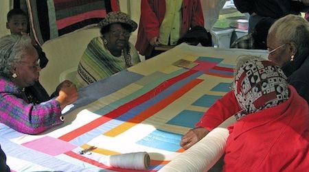 Women from Gee’s Bend work on a quilt during the 2005 ONB Magic City Art Connection in Birmingham, Alabama’s Linn Park.