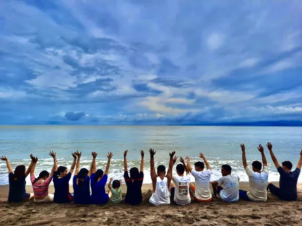 Children, adults raising their hands while on the beach in San Jose Philippines thumbnail