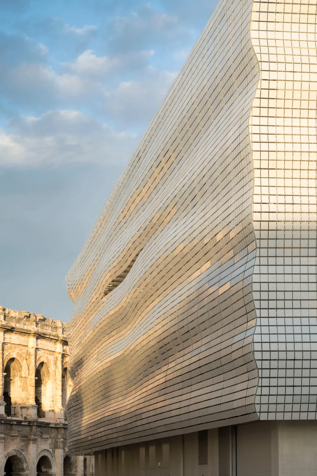 More than 6,700 glass plates ripple across the facade, reflecting its A.D. 70 neighbor.