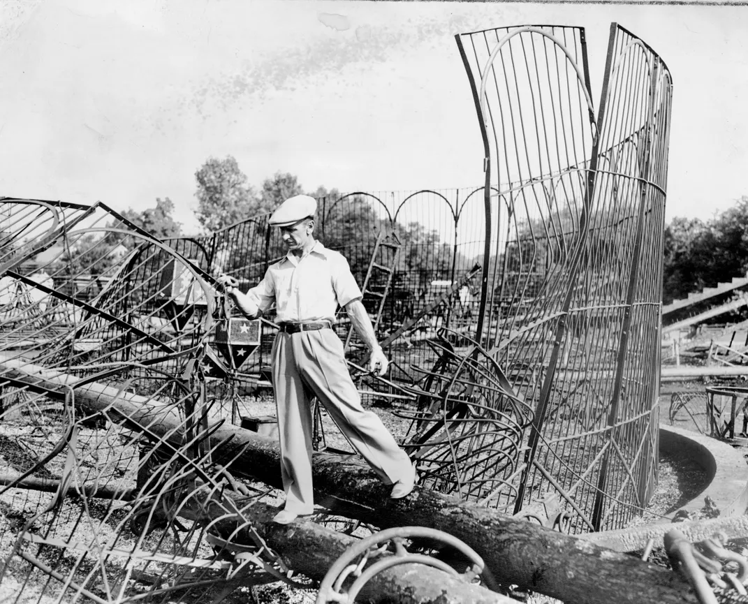 Trapeze artist Toby Wuolthing salvages twisted wire from a burned animal enclosure.