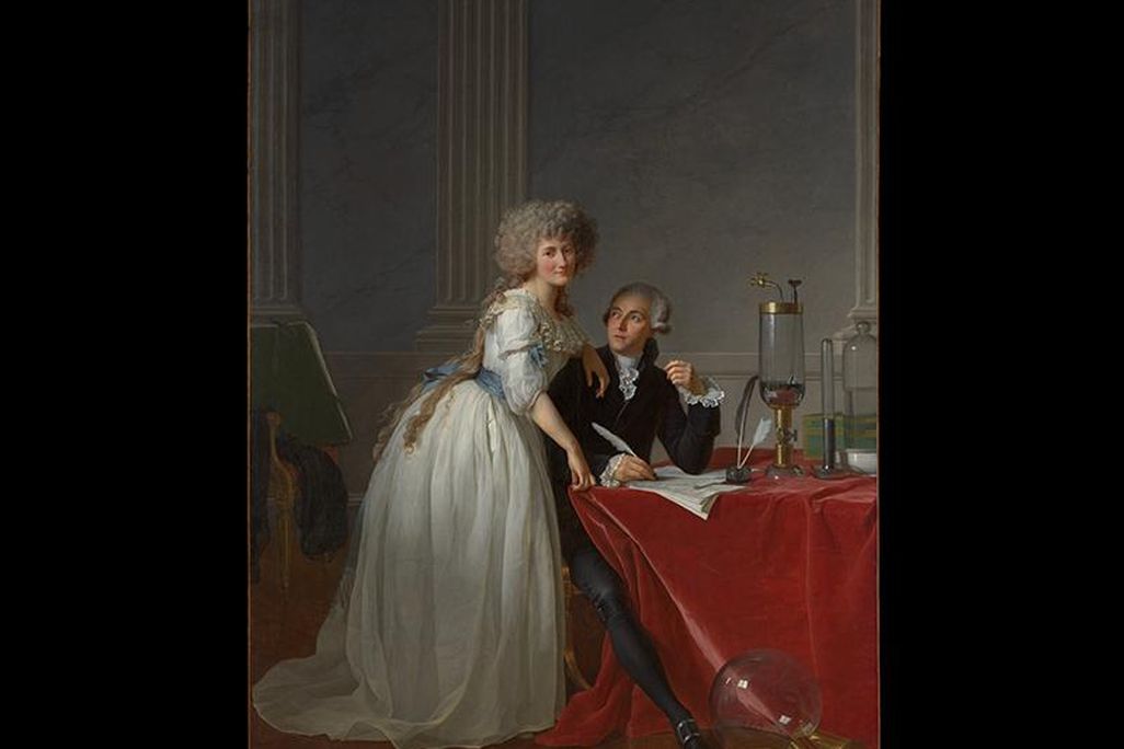 A stately portrait of a woman leaning over a desk draped with red cloth, where a man wearing a suit sits and writes, surrounded by elegant scientific equipment
