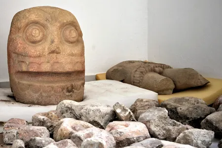 In this 2018 photo provided by Mexico's National Institute of Anthropology and History, INAH, a skull-like stone carving and a stone trunk depicting the Flayed Lord, a pre-Hispanic fertility god depicted as a skinned human corpse, are stored after being excavated from the Ndachjian–Tehuacan archaeological site in Tehuacan, Puebla state, where archaeologists have discovered the first temple dedicated to the deity. 