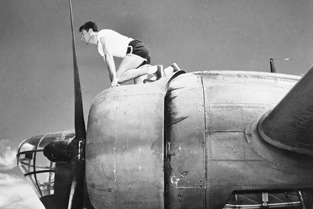 Olympian and airman Louis Zamperini crouches in his starting position on a B-18 bomber.