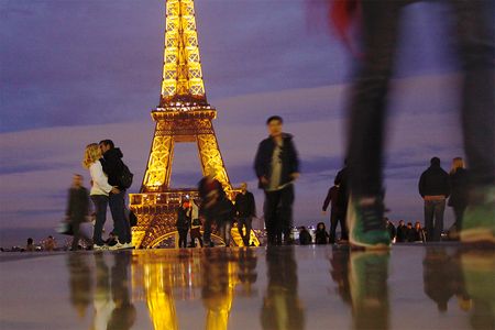 A couple kisses near the Eiffel Tower.