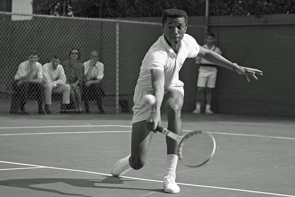 Arthur Ashe playing tennis against Dennis Ralston in 1964