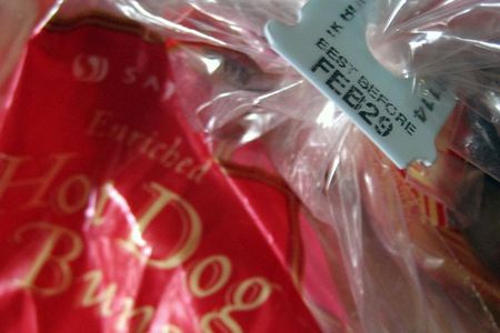 A tag sealing a bag of hot dog buns displays a best before date of February 29