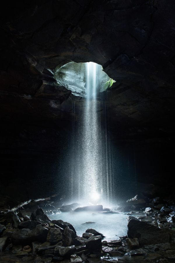 A Waterfall Cuts Through the Bedrock Into a Small Cave thumbnail
