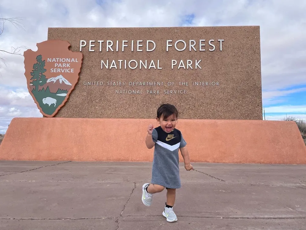 Toddler in front of national park sign