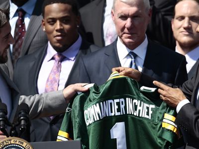 President Barack Obama is presented with a team jersey by the Green Bay Packers' quarterback Aaron Rodgers during a ceremony at the White House after Super Bowl XLV.