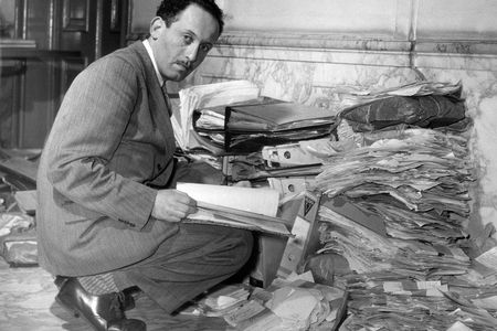 Louis de Jong, founder of Dutch Institute for War Documentation, examining documents on the Holocaust.

