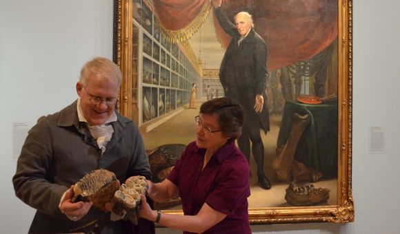 SAAM's Senior Curator Eleanor Jones Harvey and Dean Howarth take a closer look at mastodon bones in the exhibition Alexander von Humboldt and the United States: Art, Nature, and Culture. Charles Willson Peale's painting in the background shows similar bones. Photo by Carol Wilson