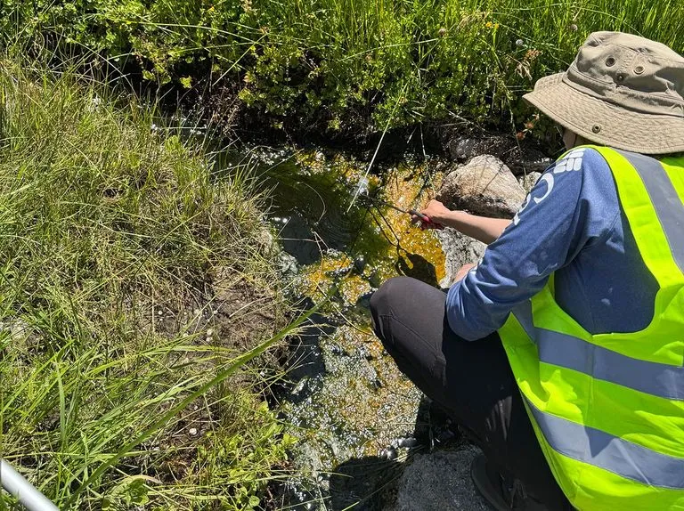 a researcher using tongs to collect water samples