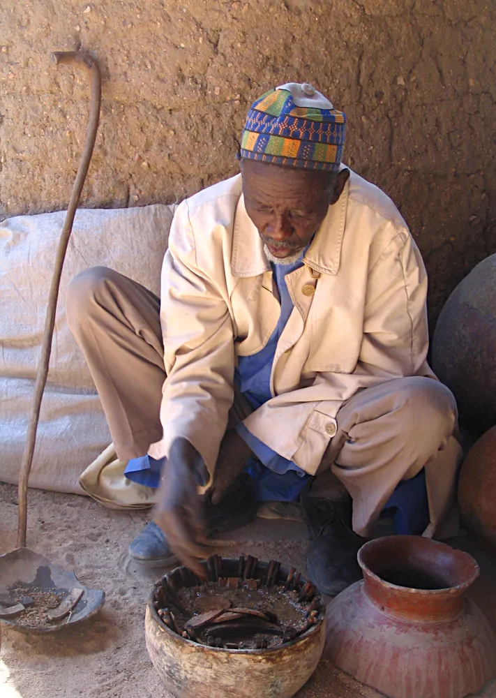 A Cameroonian man interprets the changes in position of various objects as caused by a crab during divination.