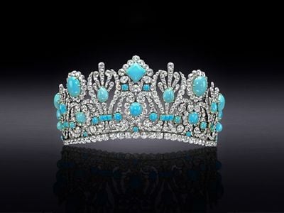 Turquoise and diamond encrusted diadem on a black background that lightens to gray in the center.