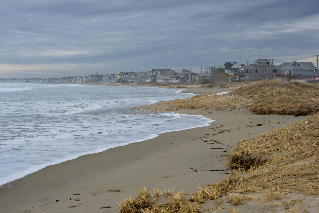 A photograph shows Wells Beach in southern Maine with beach houses on the horizon