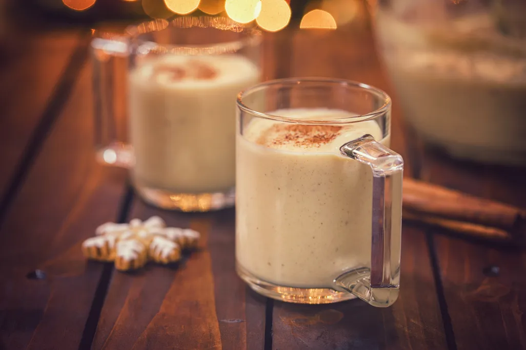 two glasses full of eggnog sit on a table