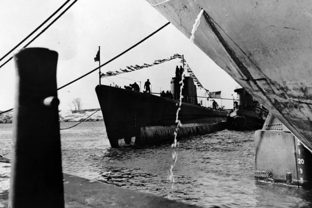 A black and white photo of a submarine on top of water