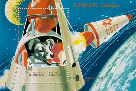 The story of Laika (above, in a postage stamp from the Emirate of Ajman, now part of the UAE) lives on today in websites, YouTube videos, poems, and children’s books, at least one of which provides a happy ending for the doomed dog. 