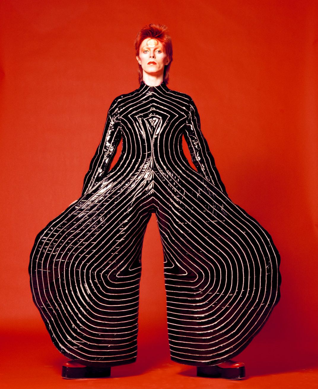 Bowie wearing a striped bodysuit designed by Kansai Yamamoto