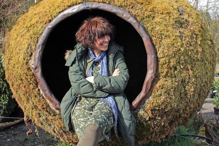 Mary Reynolds sits in a moss-covered pod designed by the West Cork artist Peter Little.