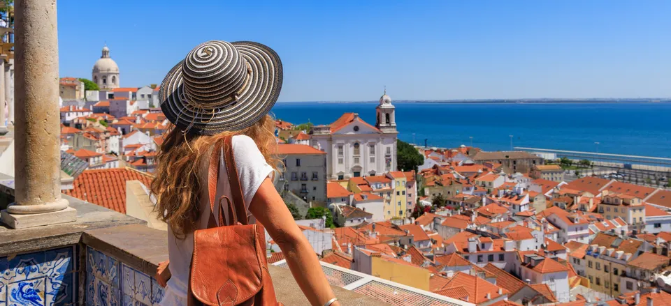 A family looking out over a scenic viewpoint in Lisbon, representing the lifestyle attainable through new residency options.